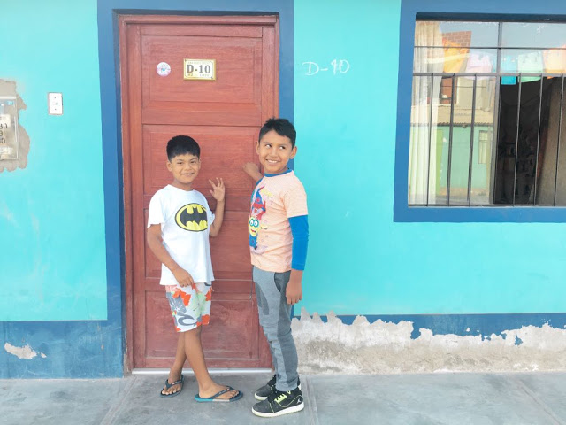 Two neighbor students, nine years old, turn and look at the camera as they knock on our door. 